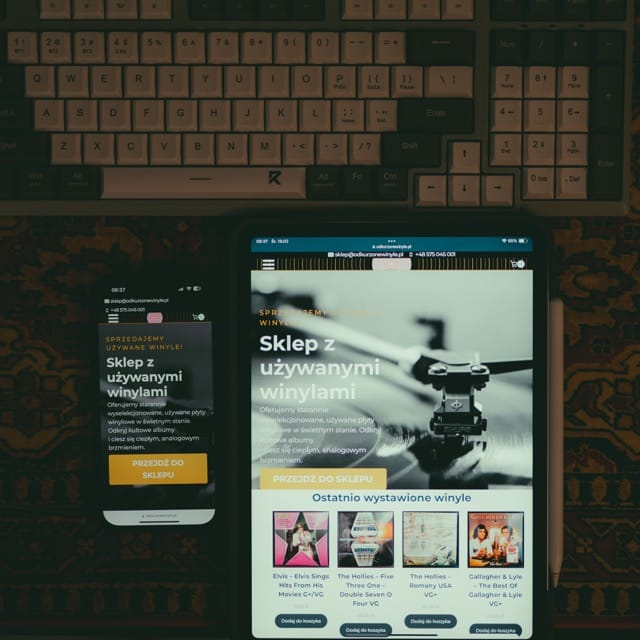 projektowanie stron www Smartfon i tablet wyświetlają stronę internetową sklepu z używanymi płytami winylowymi w języku polskim. Strona zawiera tekst promocyjny, obraz gramofonu i listę polecanych płyt winylowych. Za urządzeniami widoczna jest zabytkowa klawiatura. fotografia filmowanie augustów